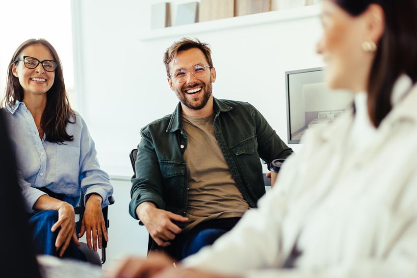 Tre personer som smiler til hverandre. Foto: Adobe stock.