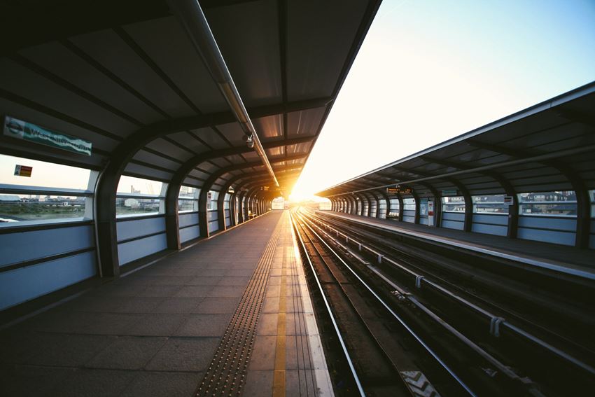 En tom togstasjon i solen. Foto: Charles Forerunner/Unsplash.